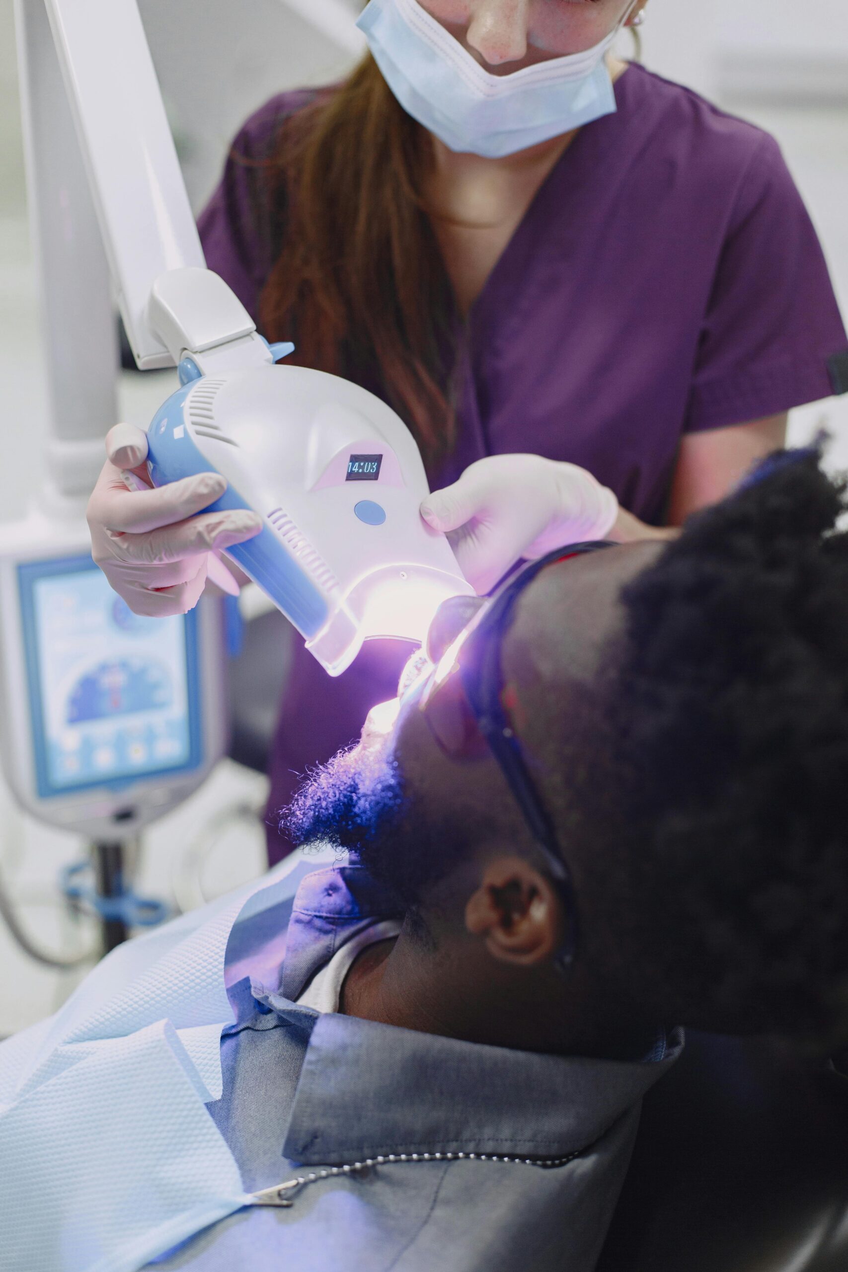 Dentist performing professional teeth whitening treatment at Pure Bliss Dental Care in Rochedale South